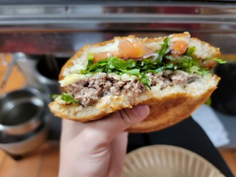 Fresh smashed burger held up in Zorro's kitchen, packed with fresh lettuce and tomato